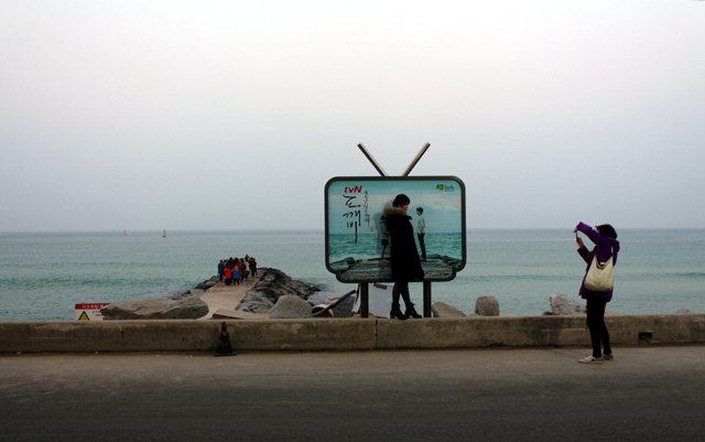 ▲ 강릉 주문진 영진해변을 찾은 관광객들이 드라마 촬영지를 배경으로 기념촬영을 하고있다