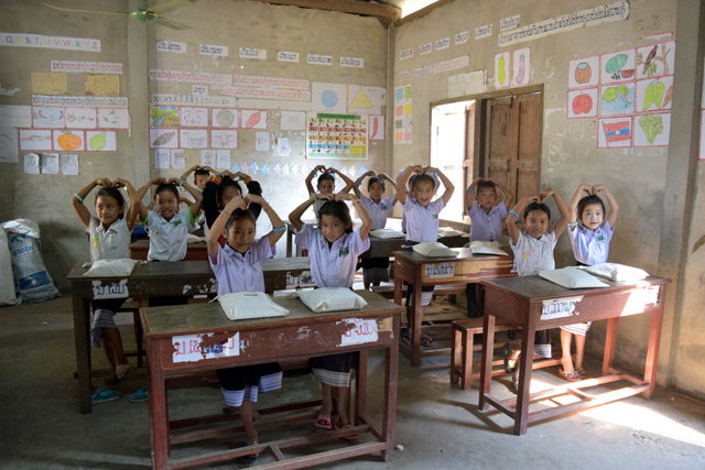 ▲ 라오스 비엔티엔 나하이 초등학교 학생들이 강원도 후원자들과 1대1 매칭한 후원 팔찌를 들어 보이고 있다.