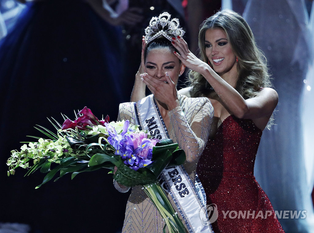 ▲ Former Miss Universe Iris Mittenaere, right, crowns new Miss Universe Demi-Leigh Nel-Peters at the Miss Universe pageant Sunday, Nov. 26, 2017, in Las Vegas. (AP Photo/John Locher)