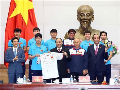 ▲ 박항서 베트남 U-23(23세 이하) 축구대표팀 감독(오른쪽 2번째)과 선수들이 1월 28일 응우옌 쑤언 푹 베트남 총리(가운데)에게 사인볼과 유니폼을 선물하고 기념사진을 찍는 모습