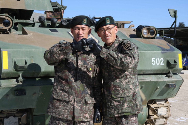 ▲ 형 김수길 원사(왼쪽)와 동생 김수만 원사가 K200장갑차 앞에서 기념촬영을 하고 있다.
