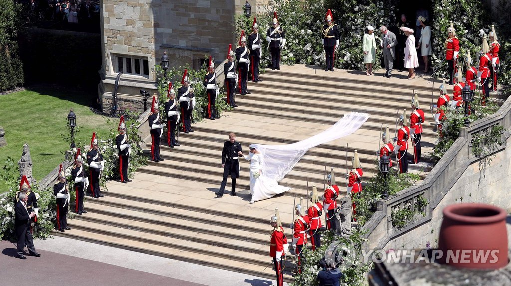 ▲ Britain's Prince Harry, Duke of Sussex and his wife Meghan, Duchess of Sussex walk down the west steps of St George's Chapel, Windsor Castle, in Windsor, on May 19, 2018 after their wedding ceremony. / AFP PHOTO / POOL / Andrew Matthews