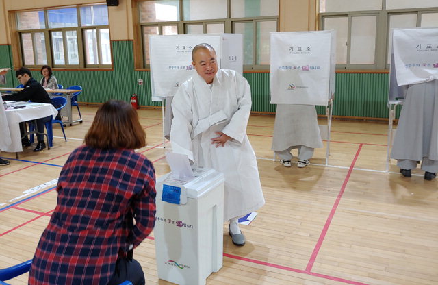 ▲ 신흥사 법검 우송 주지스님이 설악초교 체육관에서 투표를 하고 있다.
