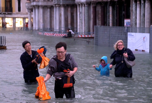 ▲ 폭우로 조수가 해수면 위 156㎝까지 급상승해 완전히 물에 잠긴 이탈리아 베네치아의 산마르코 광장에서 29일(현지시간)관광객들이 무릎 위까지 올라온 물속을 걸어다니고 있다.