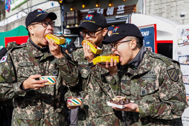▲ 11사단 병사들이 12일 홍천종합운동장에서 열린 깊은 가을 체육대회에서 음식을 먹으며 즐거워하고 있다.