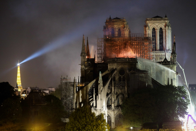 ▲ Firefighters douse flames billowing from the roof at Notre-Dame Cathedral in Paris on April 15, 2019. - A colossal fire swept through the famed Notre-Dame Cathedral in central Paris causing the spire to collapse and raising fears over the future of the nearly millenium old building and its precious artworks. The fire, which began in the early evening, sent flames and huge clouds of grey smoke billowing into the Paris sky as stunned Parisians and tourists watched on in sheer horror. (Photo by LUDOVIC MARIN / AFP)&#10;&#10;&#10;&#10;<All rights reserved by Yonhap News Agency>