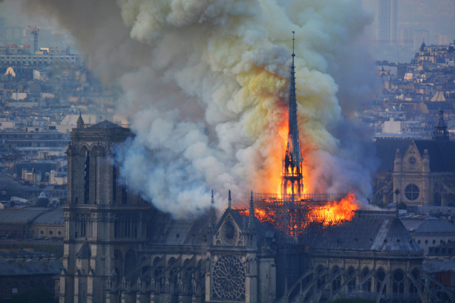 ▲ Smoke and flames rise during a fire at the landmark Notre-Dame Cathedral in central Paris on April 15, 2019, potentially involving renovation works being carried out at the site, the fire service said. - A major fire broke out at the landmark Notre-Dame Cathedral in central Paris sending flames and huge clouds of grey smoke billowing into the sky, the fire service said. The flames and smoke plumed from the spire and roof of the gothic cathedral, visited by millions of people a year, where renovations are currently underway. (Photo by Hubert Hitier / AFP)&#10;&#10;&#10;<All rights reserved by Yonhap News Agency>