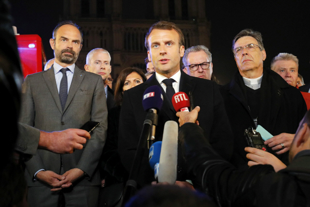 ▲ epa07509106 French President Emmanuel Macron speaks as Prime Minister Edouard Philippe and Archbishop of Paris, Michel Aupetit, stand near the Notre Dame Cathedral where a fire burns in Paris, France, 15 April 2019. A fire started in the late afternoon in one of the most visited monuments of the French capital.  EPA/PHILIPPE WOJAZER / POOL  MAXPPP OUT

&lt;All rights reserved by Yonhap News Agency&gt;