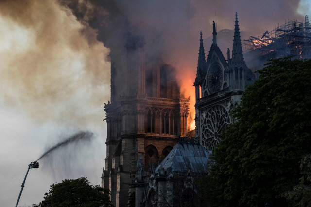 ▲ Firefighters douse flames billowing from the roof at Notre-Dame Cathedral in Paris on April 15, 2019. - A huge fire swept through the roof of the famed Notre-Dame Cathedral in central Paris on April 15, 2019, sending flames and huge clouds of grey smoke billowing into the sky. The flames and smoke plumed from the spire and roof of the gothic cathedral, visited by millions of people a year. A spokesman for the cathedral told AFP that the wooden structure supporting the roof was being gutted by the blaze. (Photo by THOMAS SAMSON / AFP)

&lt;All rights reserved by Yonhap News Agency&gt;