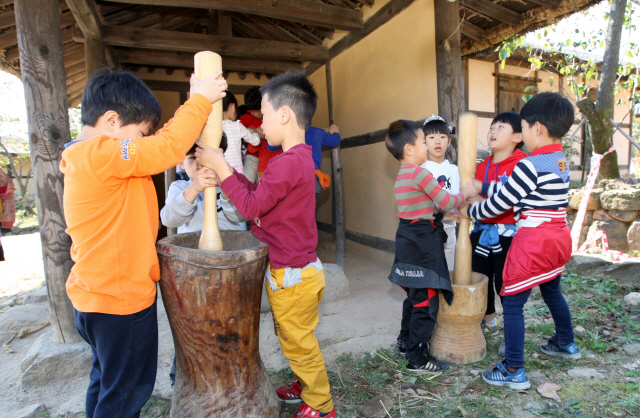 ▲ 왕곡마을을 찾은 어린이들이 절구에 곡식찧는 체험을 하고 있다.