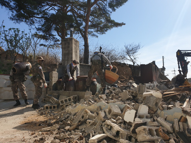 ▲ 102기갑여단 33전차대대 장병들이 17일 장천마을에서 산불피해 농가의 비닐하우스 구조물 등을 철거하고 있다.