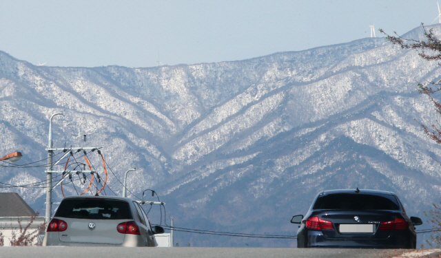 ▲ 11일 강원 강릉 시내에서 차량이 하얀 눈이 쌓여 있는 대관령을 바라보며 운행하고 있다. 2019.4.11
