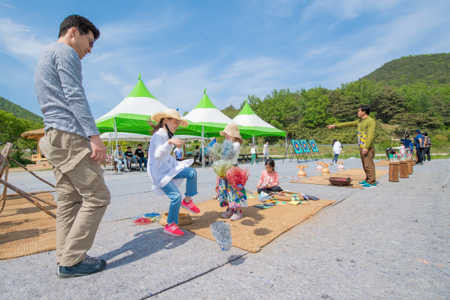 ▲ 어린이날인 지난 5일 고성 왕곡마을을 찾은 가족단위 관광객들이 지게체험,제기차기 등 전통놀이 체험을 즐기고 있다.