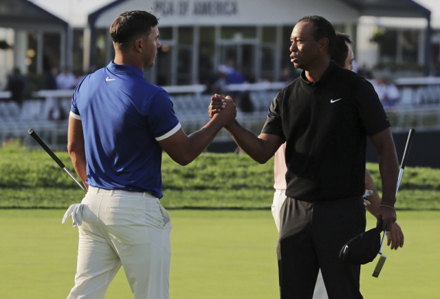 ▲ Brooks Koepka, left, shakes hands with Tiger Woods after finishing the second round of the PGA Championship golf tournament, Friday, May 17, 2019, at Bethpage Black in Farmingdale, N.Y. (AP Photo/Charles Krupa)