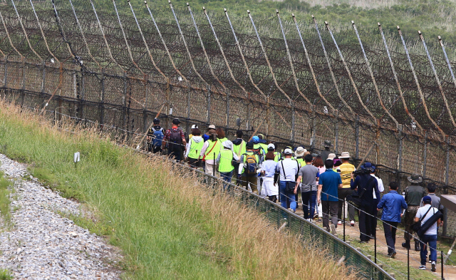 강원 고성 DMZ 평화의 길 개방 두 달을 하루 앞둔 26일 A코스 탐방에 나선 방문객들이 해안철책을 따라 걷고있다. 지난 4월 27일 일반에 개방된 고성 DMZ 평화의길에는 지난 25일까지 4천974명이 찾았다.