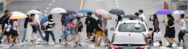 ▲ 장맛비가 내리기 시작한 10일 춘천중앙로터리에서 우산을 쓴 시민들이 횡단보도를 건너고 있다.   최유진