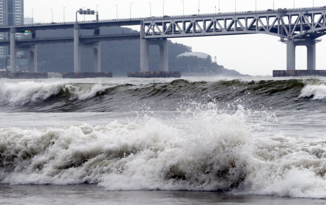 제5호 태풍 ‘다나스’가 북상 중인 19일 오후 부산 광안대교를 통과한 높은 파도가 광안리해수욕장 해변을 덮치고 있다. 