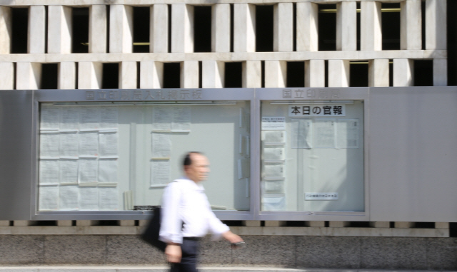7일 일본 경제산업성이 한국을 수출관리 상의 일반포괄허가 대상인 이른바 ‘백색국가’(화이트리스트)에서 제외하는 내용의 수출무역관리령 개정안을 공포한 가운데, 도쿄 도라노몬 국립인쇄국 벽면에 내걸린 관보 앞을 행인이 지나고 있다.