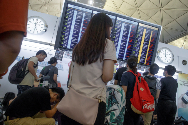 ▲ Passengers look at the departure board after all flights leaving Hong Kong were cancelled due to a protest inside the airport terminal in Hong Kong, China August 12, 2019. REUTERS/Thomas Peter