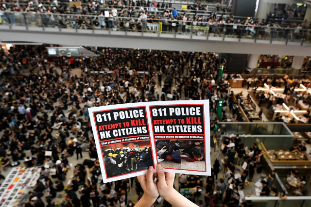 ▲ TOPSHOT - CORRECTION - Pro-democracy protesters gather against the police brutality and the controversial extradition bill at Hong Kong‘s international airport on August 12, 2019. - Hong Kong airport authorities cancelled all remaining departing and arriving flights at the major travel hub on August 12, after thousands of protesters entered the arrivals hall to stage a demonstration. (Photo by Manan VATSYAYANA / AFP) / CORRECTING THE WHOLE CAPTION