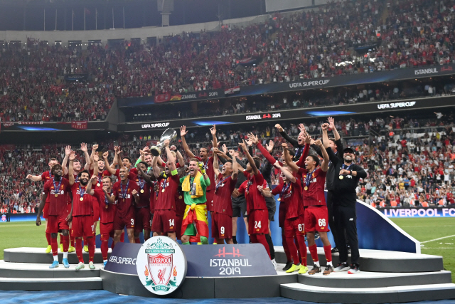 ▲ Liverpool players celebrate on the podium after winning the UEFA Super Cup 2019 football match between FC Liverpool and FC Chelsea at Besiktas Park Stadium in Istanbul on August 14, 2019. (Photo by Bulent Kilic / AFP)