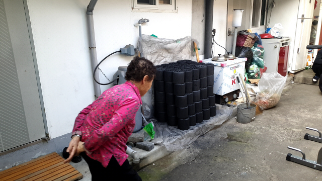 ▲ 31일 춘천 소양로의 한 주택에서 이모 할머니가 마당에 쌓인 연탄을 근심 가득한 얼굴로 바라보고 있다.