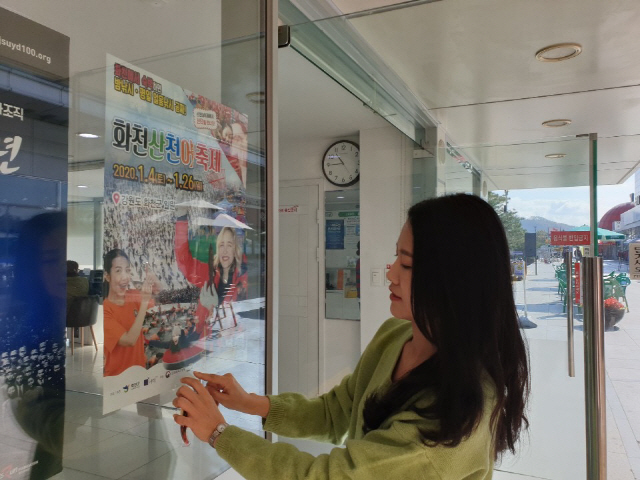 ▲ 화천군청 직원들이 4일 여주 고속도로 휴게소를 방문해 2020 화천산천어축제 홍보 포스터를 부착하고 있다.
