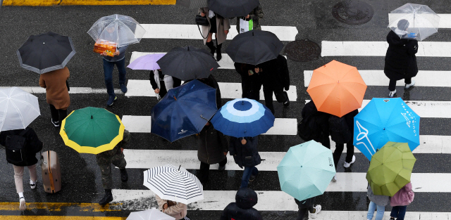 ▲ 겨울을 재촉하는 비가 내린 17일 춘천 명동에서 형형색색의 우산을 쓴 시민들이 건널목을 건너고 있다.기상청은 18일 오전까지 비가 온 뒤 기온이 크게 떨어질 것으로 전망했다.   최유진