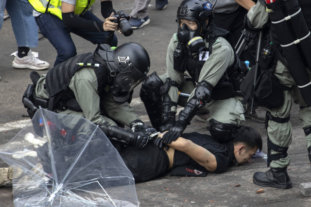 ▲ 홍콩 경찰이 18일 홍콩이공대학에 진입, 한 시위자의 손을 결박하고 있다.