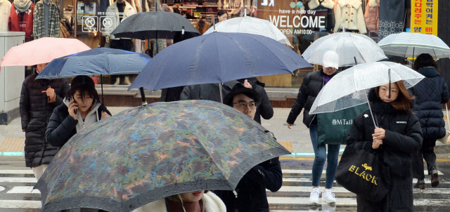 ▲ 겨울비가 내린 7일 춘천 명동에서 시민들이 우산을 쓰고 걷고 있다.  방병호
