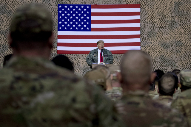 ▲ FILE - In this Dec. 26, 2018, file photo, President Donald Trump speaks to members of the military at a hangar rally at Ain al-Asad air base, Iraq. Iran struck back at the United States for the killing of a top Iranian general early Wednesday, Jan. 8, 2020, firing a series of ballistic missiles at Iraqi bases housing U.S. troops in a major escalation of tensions that brought the two longtime foes closer to war. (AP Photo/Andrew Harnik, File)