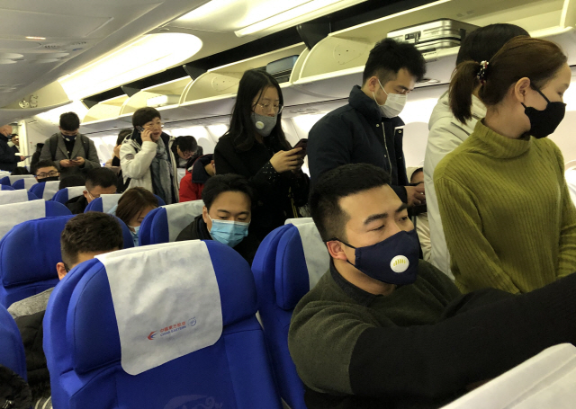 ▲ 21일 중국 상하이(上海)를 출발해 우한(武漢)으로 향하는 항공기에 탄 승객들이 신종 코로나바이러스 감염을 막고자 마스크를 쓰고 있다. 2020.1.21