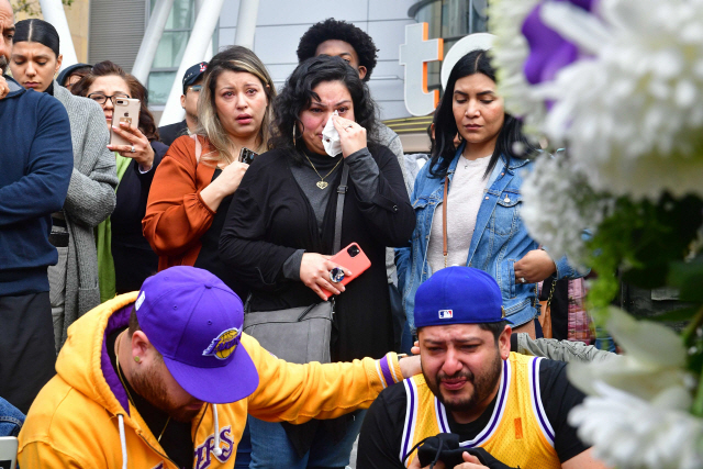 ▲ People gather around a makeshift memorial for former NBA and Los Angeles Lakers player Kobe Bryant after learning of his death at LA Live plaza in front of Staples Center in Los Angeles on January 26, 2020. - NBA legend Kobe Bryant died January 26, 2020 in a helicopter crash in suburban Los Angeles, celebrity website TMZ reported, saying five people are confirmed dead in the incident. (Photo by Frederic J. Brown / AFP)&#10;<All rights reserved by Yonhap News Agency>