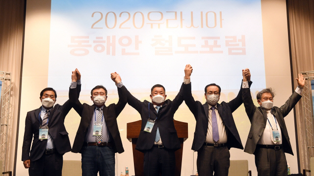 ▲ 2020유라시아 동해안 철도포럼이 21일 강릉 라카이 샌드파인 컨벤션센터에서 열렸다. 이날 본행사인 세션II 유라시아 철도포럼 서밋에서 김형익 동해북부선 연결 강원추진위원장(가운데)과 강릉·속초·고성·양양 추진위원장이 손을 맞잡고 동해북부선 추진에 힘을 모을 것을 다짐하고 있다. 최유진