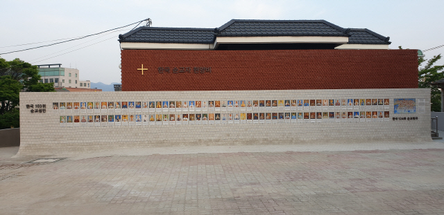 ▲ 한국 순교성인 103위의 초상화가 26일 춘천 운교동 성당 순교자 현양비에 걸렸다.