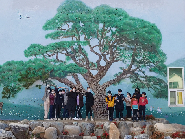▲ 산솔아동센터 어린이들이 산솔면사무소 벽면에 솔고개 소나무 벽화를 완성했다.