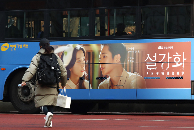 ▲ 29일 서울 마포구 일대에서 역사왜곡 논란에 휩싸인 JTBC 드라마 ‘설강화’ 포스터가 붙은 버스가 운행을 하고 있다. ‘설강화’는 1987년 서울을 배경으로 여대상 영로(지수)와 북한에서 온 간첩 수호(정해인)의 사랑을 그린 작품으로 지난 3월 시놉시스 일부가 유출되면서부터 역사 왜곡 논란이 일었다. 2021.12.29