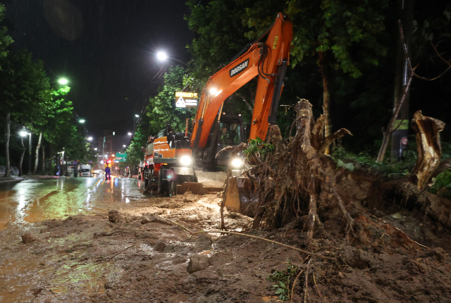 ▲ 폭우가 내린 9일 오전 서울 서초구의 한 도로에 산사태가 발생해 일부 차선 통제와 복구 작업이 이뤄지고 있다.연합뉴스