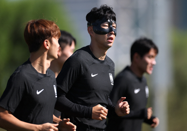 ▲ 검정 마스크를 쓴 한국 축구대표팀 손흥민(가운데)이 23일(현지시간) 카타르 도하 알에글라 훈련장에서 훈련을 받고 있다. 연합뉴스