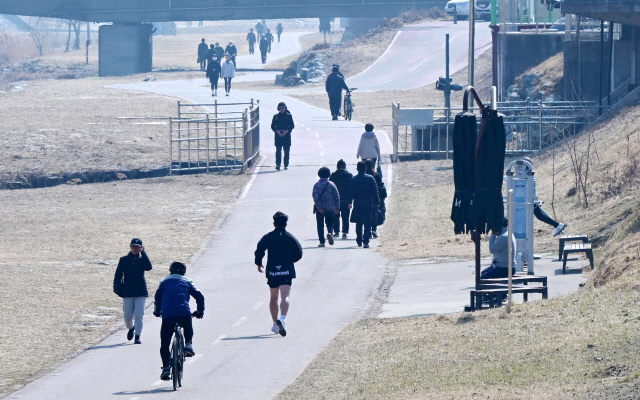▲ 도내 대부분지역이 오후들어 포근한 날씨를 보인 지난 14일 춘천 공지천 산책로에서 시민들이 산책을 하고 있다. 김정호