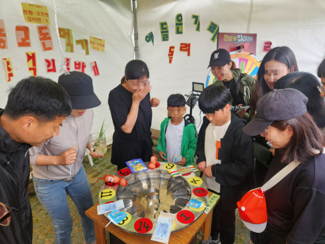 ▲ 2024 강릉단오제 ‘추억의 단오’ 특설무대장 입구에 마련된 물방개 야바위 코너에 사람들의 발걸음이 이어지고 있다.  이연제