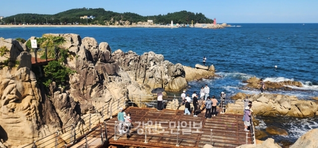 ▲ 고성군의 관광명소인 능파대를 찾은 관광객들이 청정 바다를 배경으로 인생 사진을 찍고 있다.