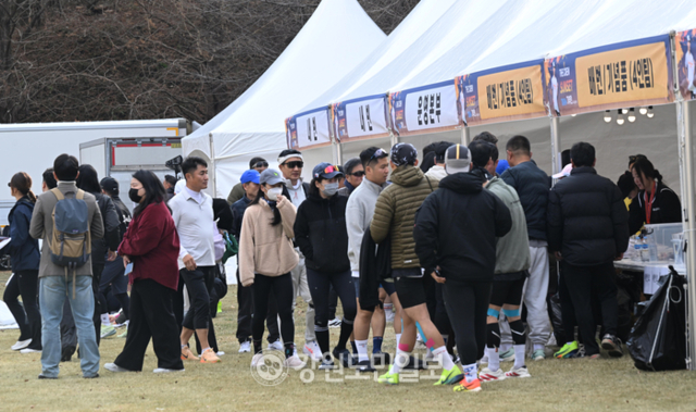 ▲ ‘더 크루 선셋 10km 기부런’대회가 22일 춘천 강촌일원에서 열렸다. 참가자들이 기념품과 배번을 받기 위해 순서를 기다리고 있다. 김정호 기자