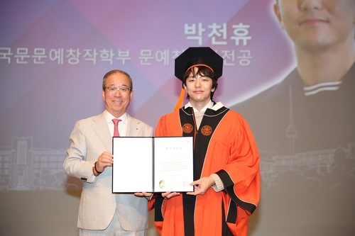 ▲ 박천휴 작가(오른쪽)가 동국대에서 명예졸업장을 받고 윤재웅 동국대 총장과 기념사진을 촬영하고 있다. 동국대 제공